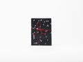 Printed paper folded like an accordion with an inverted white and black bird photo and red string bow on a white background